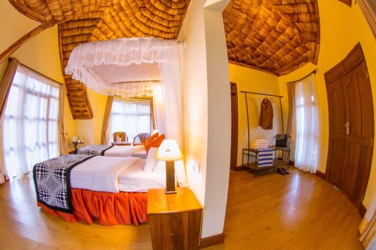 Wide view of a guest room with bed and seating at Farm of Dreams Lodge, Karatu